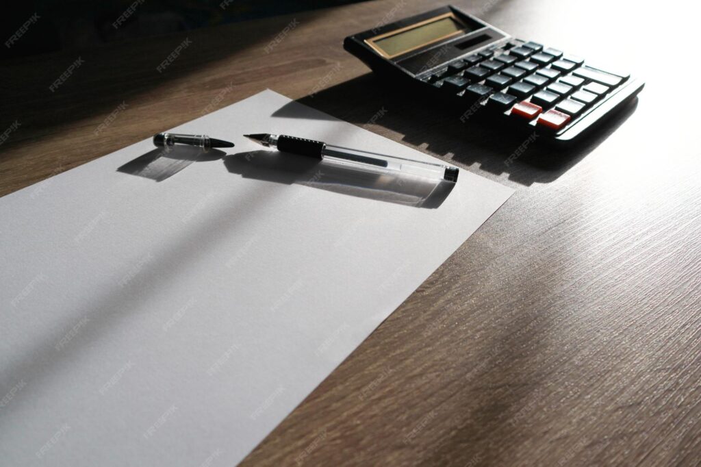 buy a business - Calculator and pencil with shadow light Office desk table with supplies Flat lay